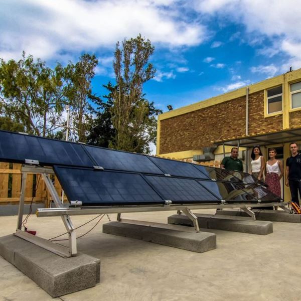 five people near a solar panel