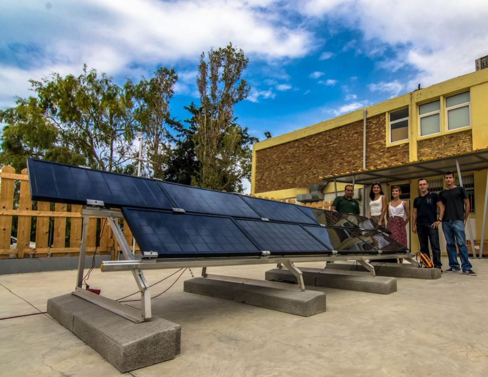 five people near a solar panel