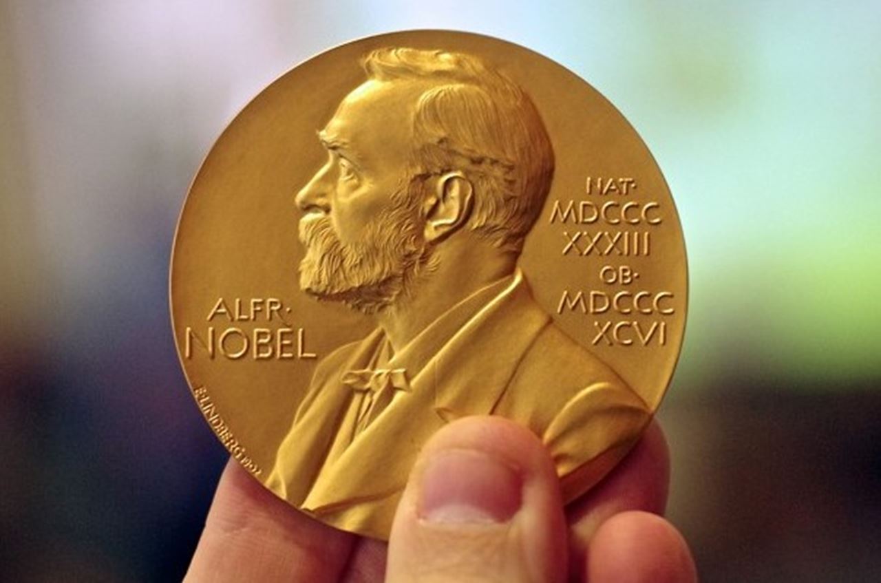 A golden medallion with an embossed image of Alfred Nobel.