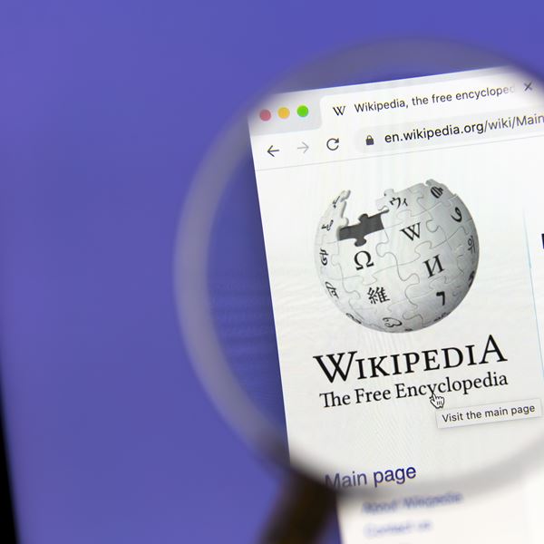 Wikipedia website under a magnifying glass.