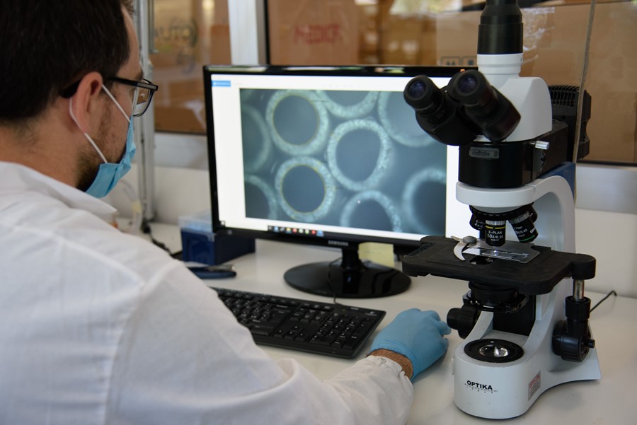 man looking at a microscope image on a screen